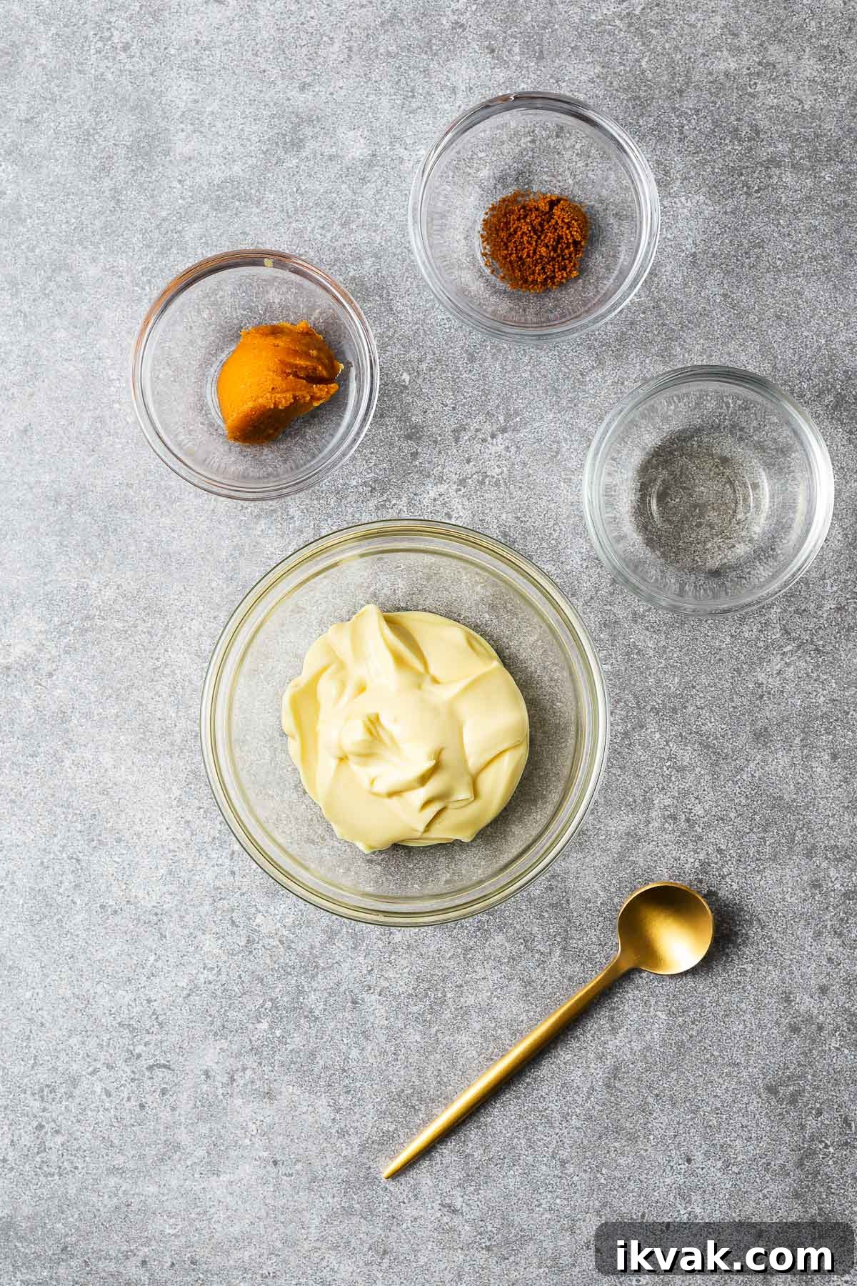 The ingredients for miso mayo arranged in small glass bowls including kewpie mayonnaise, mirin, white miso paste and hondashi (an optional ingredient).