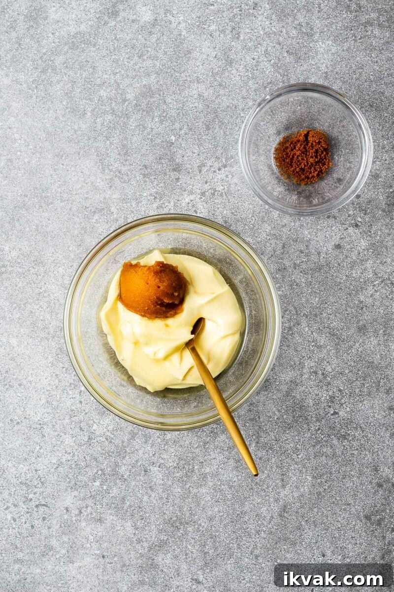 A small bowl with kewpie mayonnaise, white miso paste and mirin before being mixed with half a teaspoon hondashi powder in a separate small bowl.