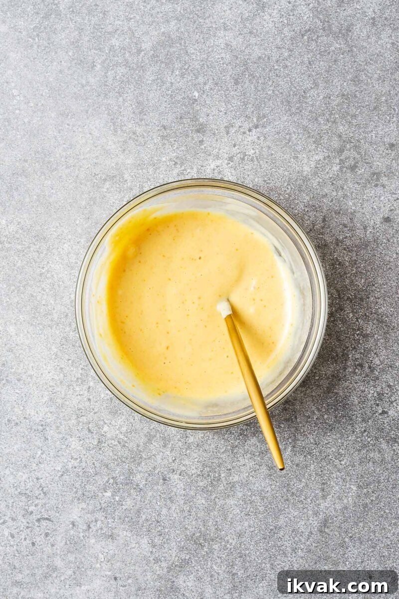 Mixed miso mayonnaise in a glass bowl with a spoon.