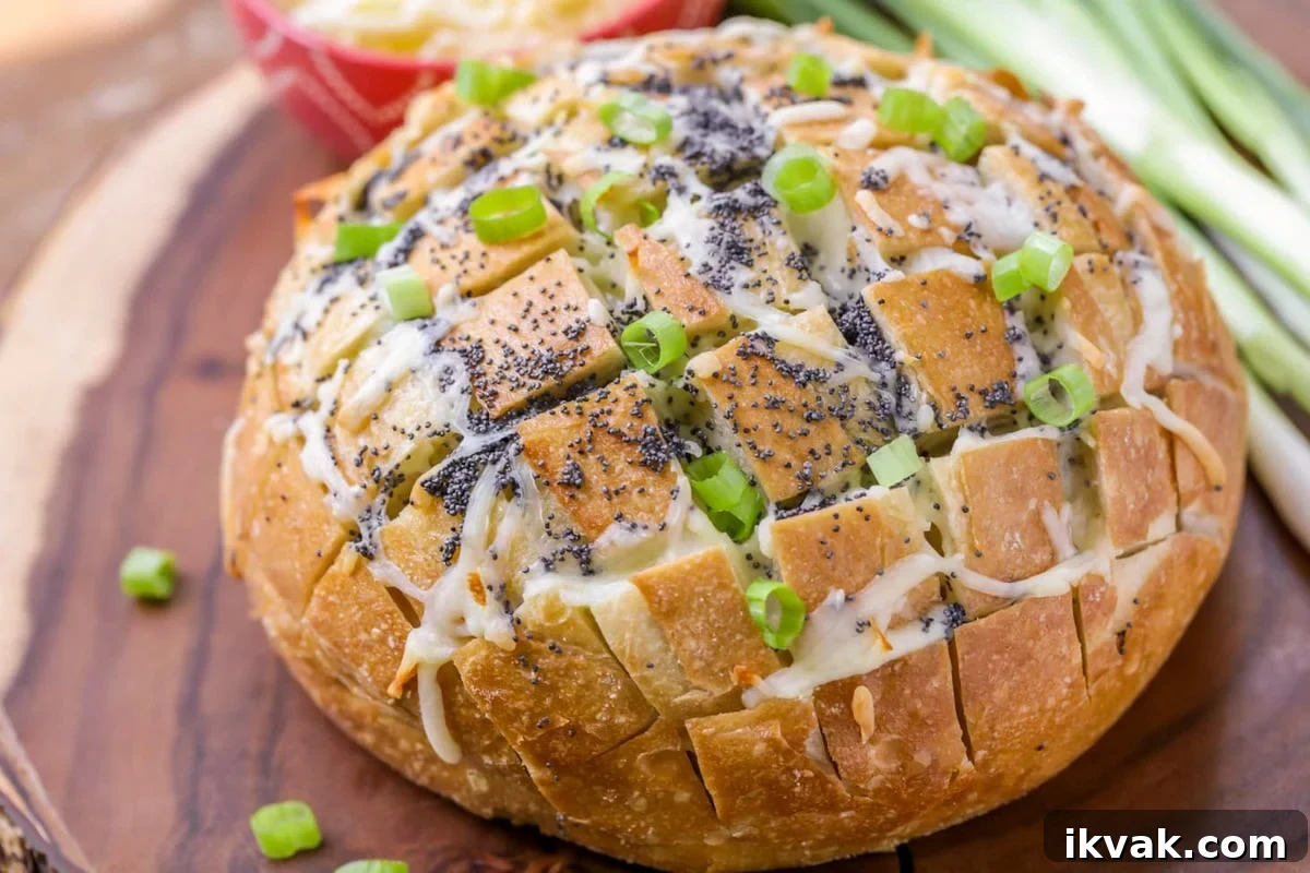 Pull Apart Bread is a favorite appetizer and perfect for sharing. There is cheesy, delicious goodness in every bite! Baked Pull Apart Bread topped with cheese and green onions.