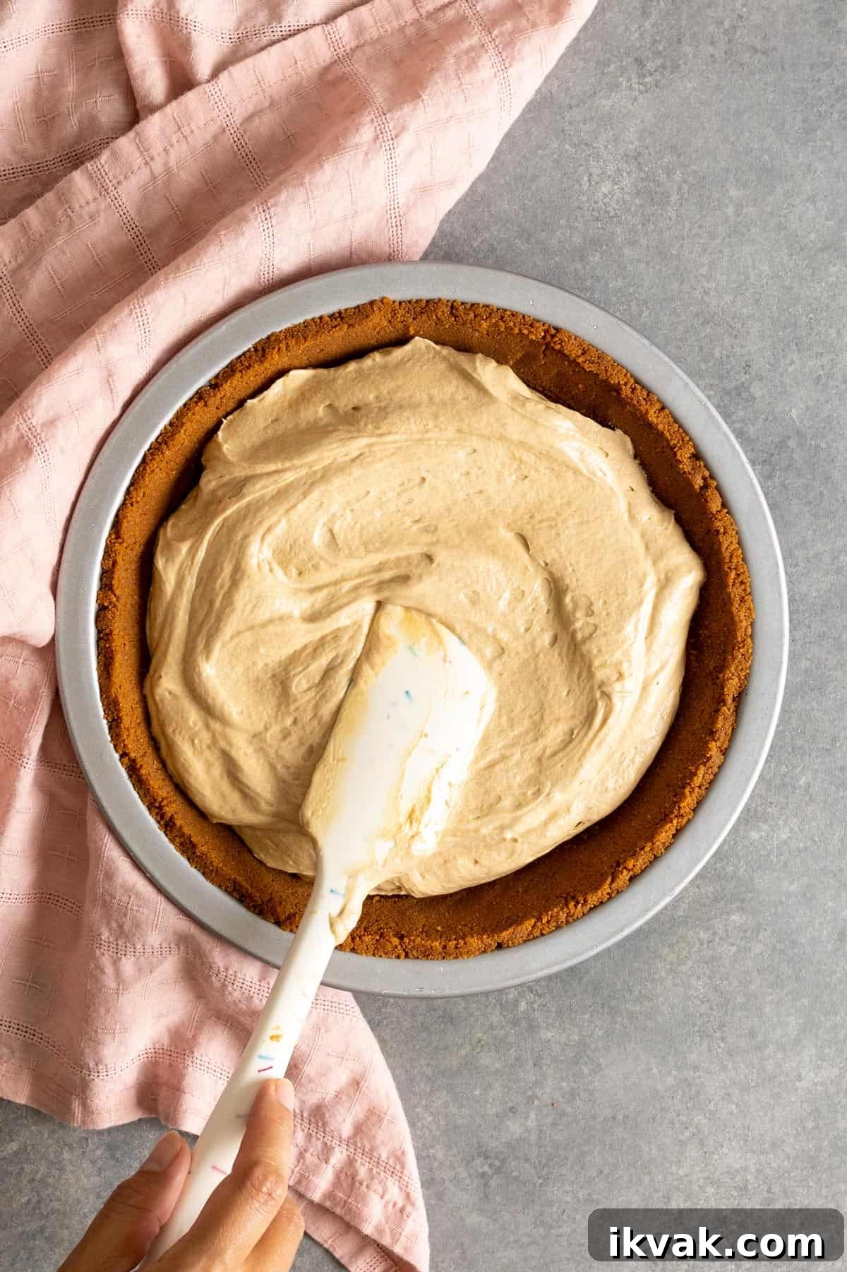 Adding filling to a no bake Biscoff pie crust.