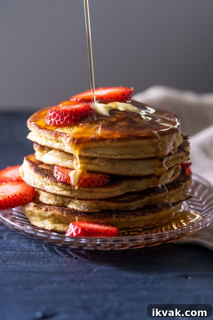 Keto Lupin Pancakes: Extra-Fluffy Low-Carb Recipe 2 A stack of keto pancakes with sugar free syrup and strawberry slices