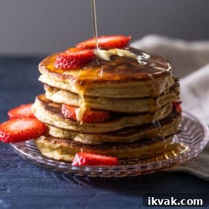 Keto Lupin Pancakes: Extra-Fluffy Low-Carb Recipe 6 A stack of keto pancakes with sugar free syrup and strawberry slices