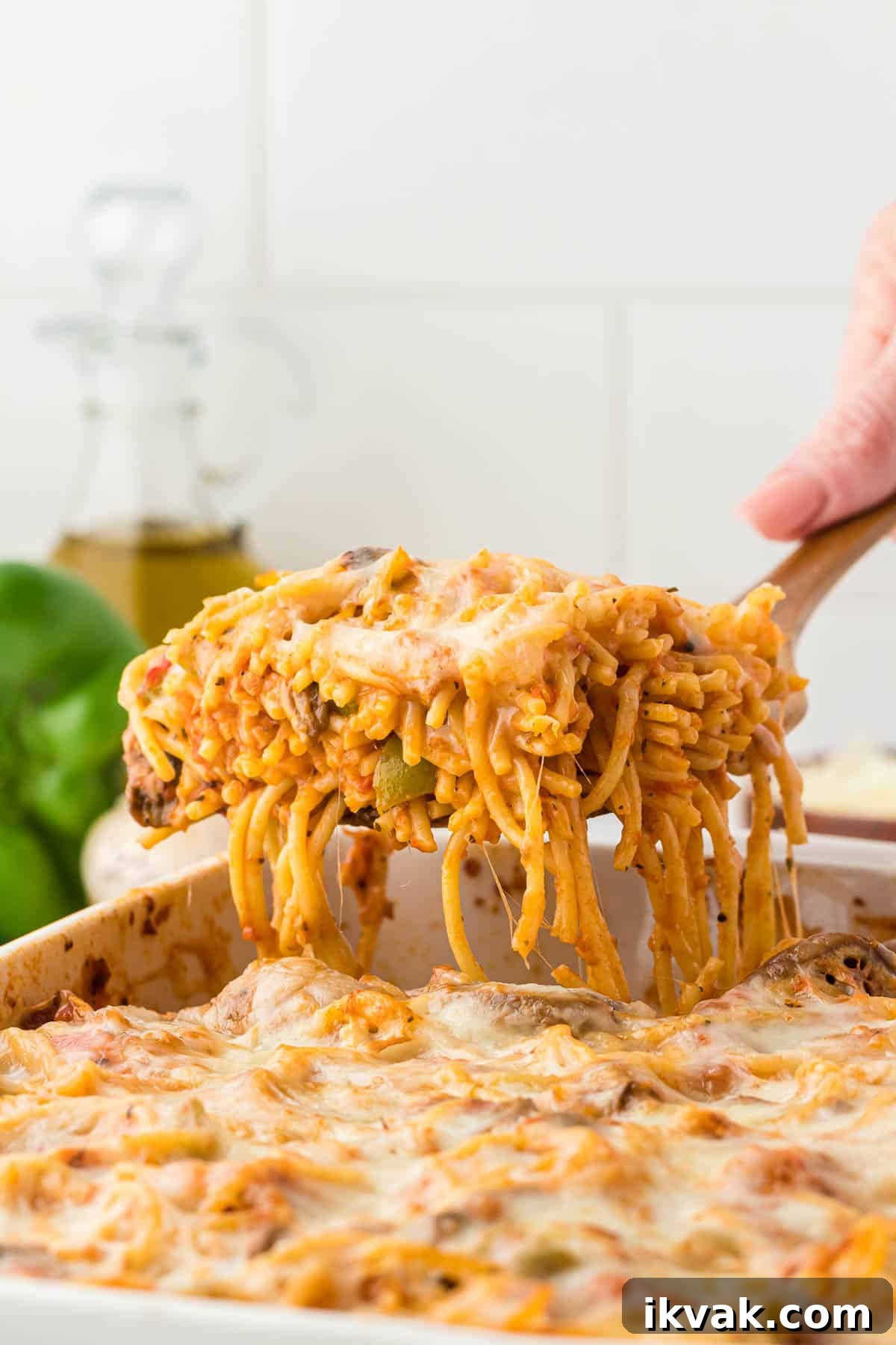 Vegetarian Baked Spaghetti with Mozzarella and Roasted Veggies 2 taking a serving of spaghetti bake from the dish