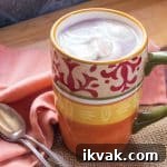 Baileys Hot Chocolate with Coconut Whipped Cream Recipe 3 A cup of hot cocoa topped with coconut whipped cream, and 2 spoons.