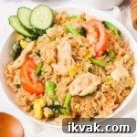 Thai fried rice with sliced cucumbers on the plate.