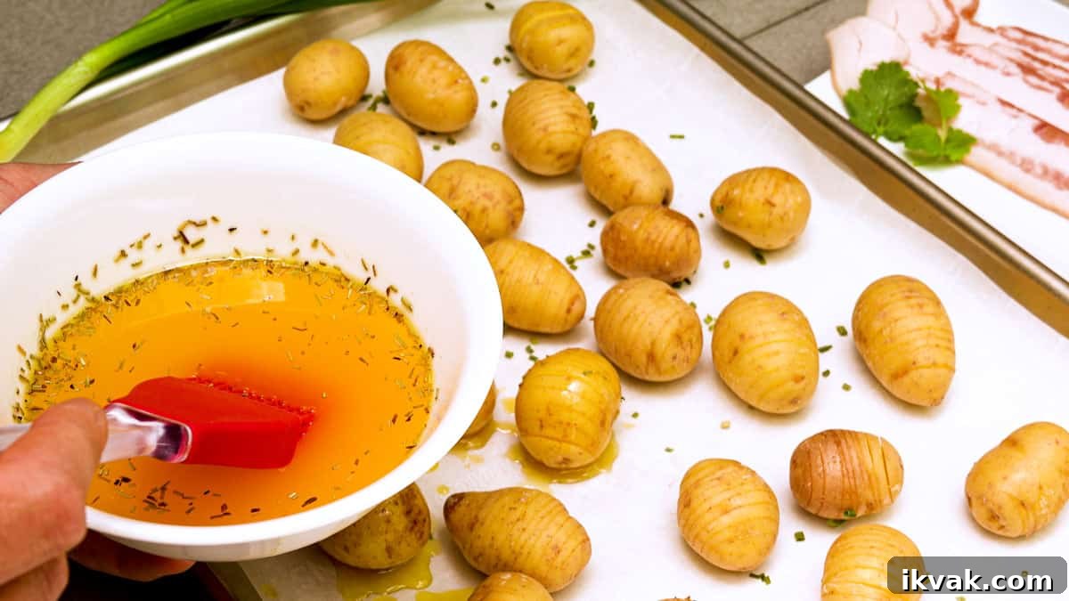 buttering potatoes on baking sheet
