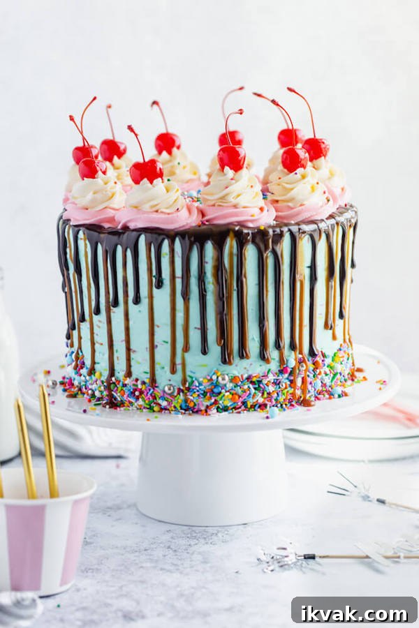 chocolate cake filled with vanilla sprinkle, caramel and chocolate buttercream and covered in a teal sprinkle frosting, topped with maraschino cherries and decorated with more sprinkles.