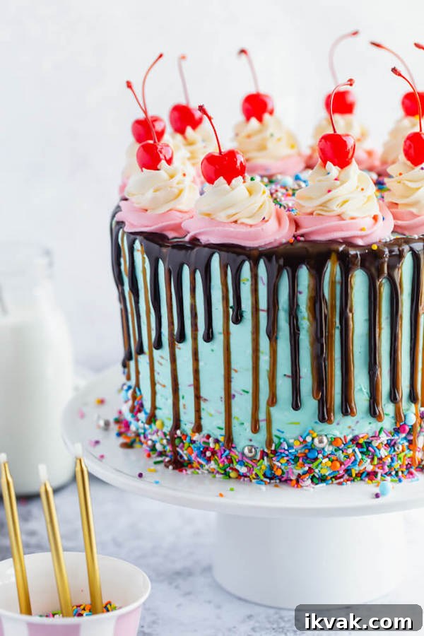 chocolate cake filled with vanilla sprinkle, caramel and chocolate buttercream and covered in a teal sprinkle frosting, topped with maraschino cherries and decorated with more sprinkles.