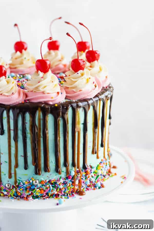 chocolate cake filled with vanilla sprinkle, caramel and chocolate buttercream and covered in a teal sprinkle frosting, topped with maraschino cherries and decorated with more sprinkles.