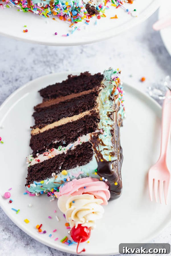chocolate cake filled with vanilla sprinkle, caramel and chocolate buttercream and covered in a teal sprinkle frosting, topped with maraschino cherries and decorated with more sprinkles.