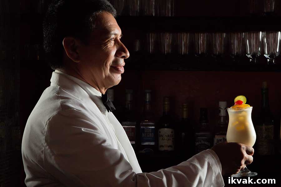 a man holding a glass of Mango Piña Colada