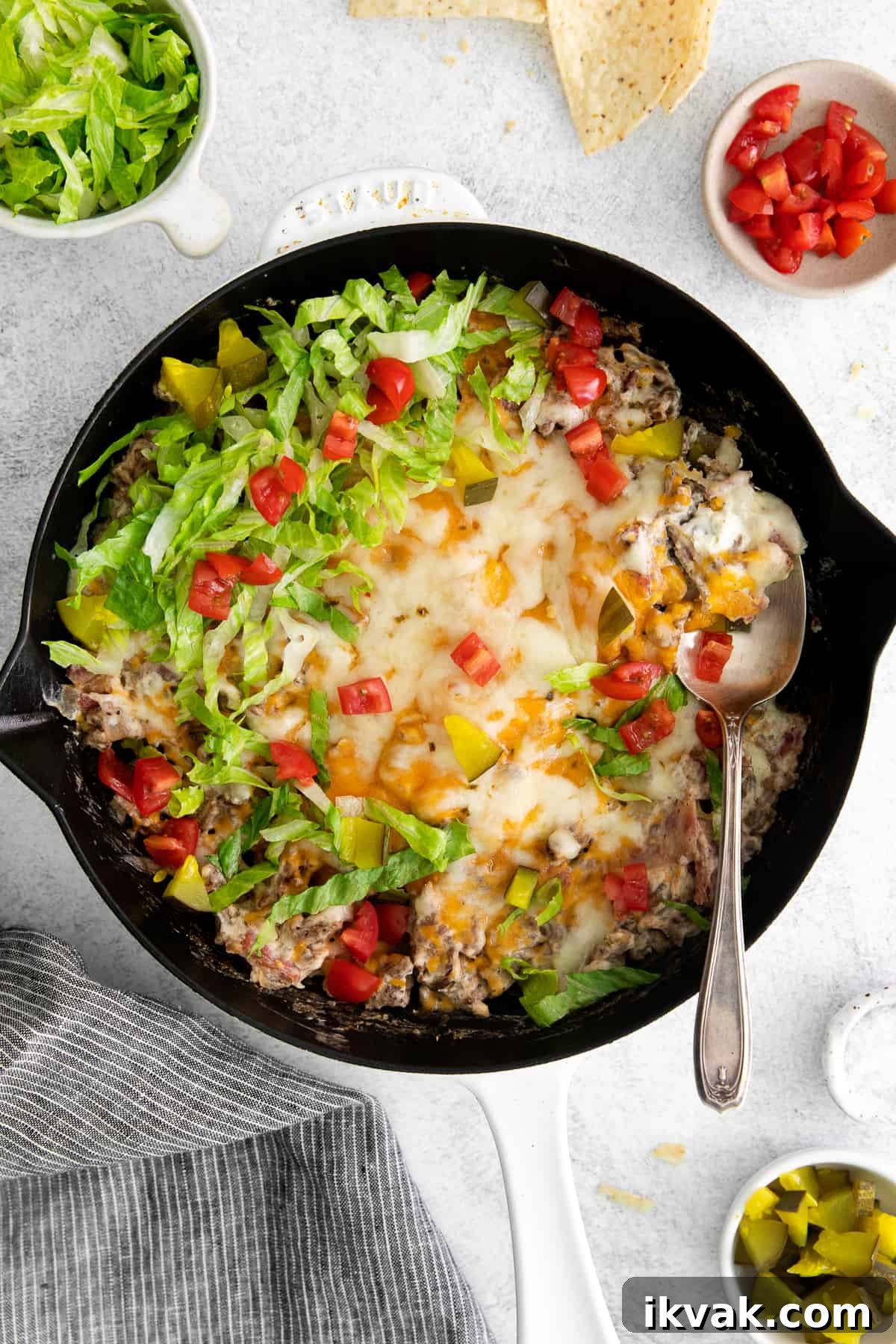 Loaded Cheeseburger Dip Recipe: Crowd-Pleasing Party Appetizer 2 Cheeseburger dip in a skillet with burger toppings.