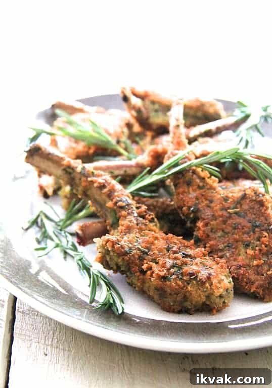 Photo of Parmesan and Herb-Crusted Lamb Chops on platter garnished with rosemary.