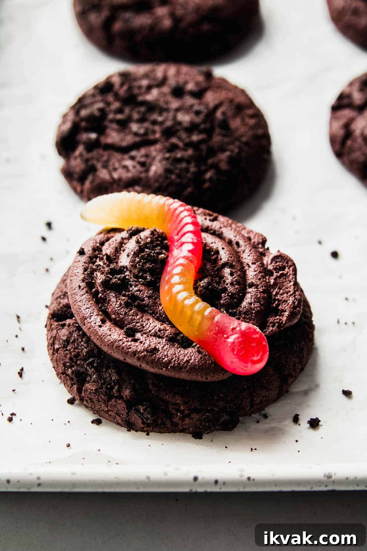 Gluten-free Oreo crumbl cookie topped with red and yellow gummy worm.