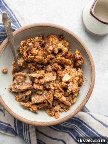Granola in a rustic bowl with a blue cloth.
