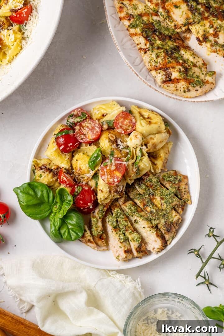 Thin grilled chicken breast served with caprese tortellini pasta salad, cherry tomatoes, mozzarella cheese, pine nuts, basil, and parmesan cheese