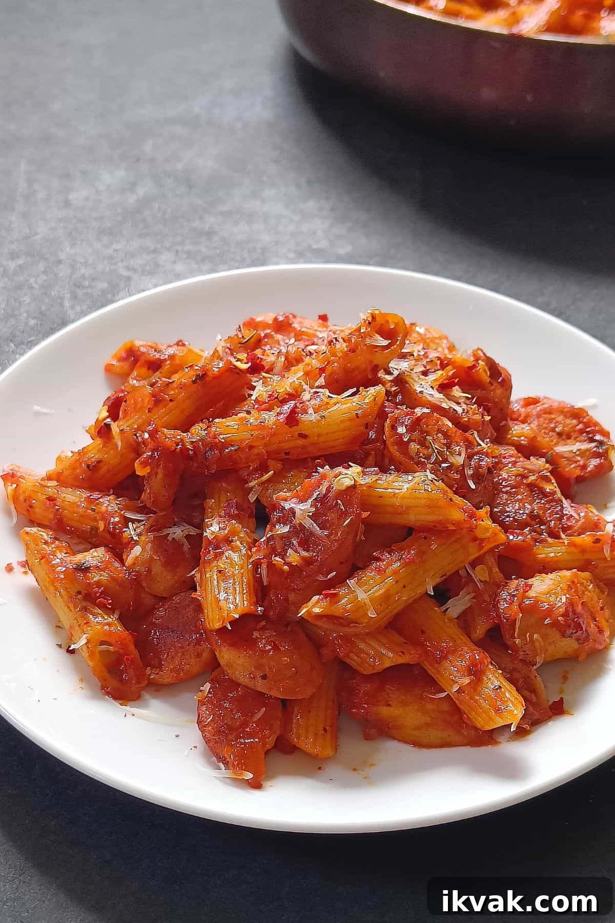 Image showing vibrant looking spicy sausage pasta on a white plate.