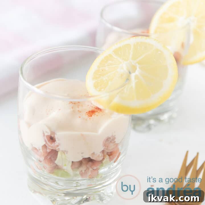 a glass filled with shrimp ice berg lettuce and sauce.