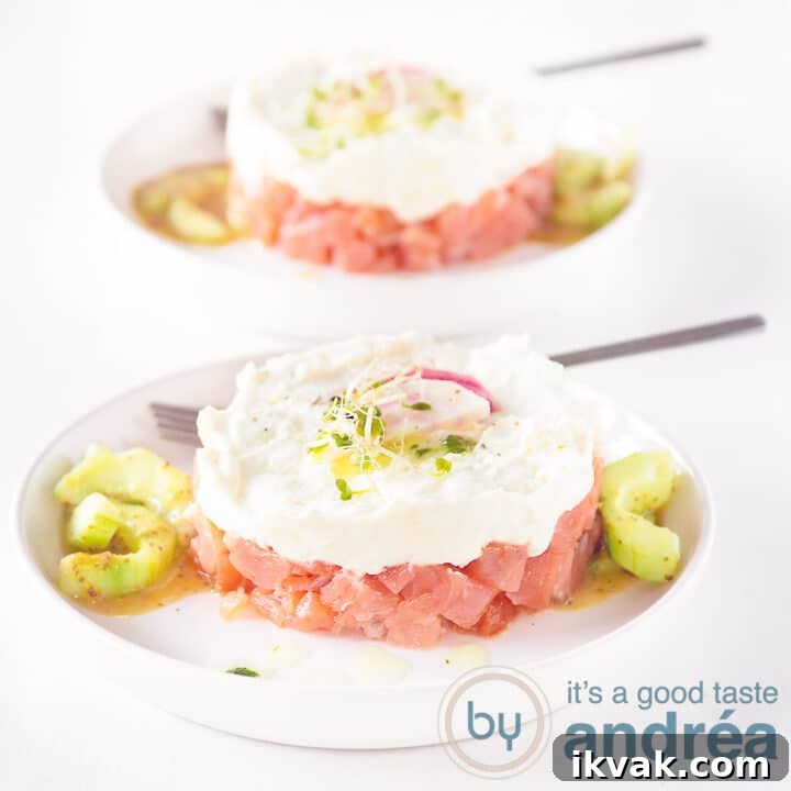 A square photo with two plates with a smoked salmon, honey and goat cheese tower on a white background.