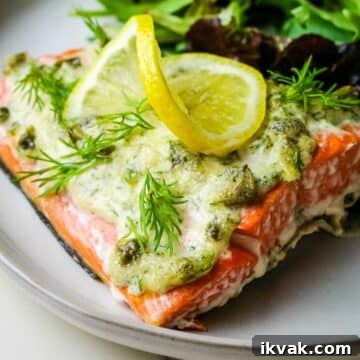 salmon fillet with mayo sauce on top and fresh slice of lemon.