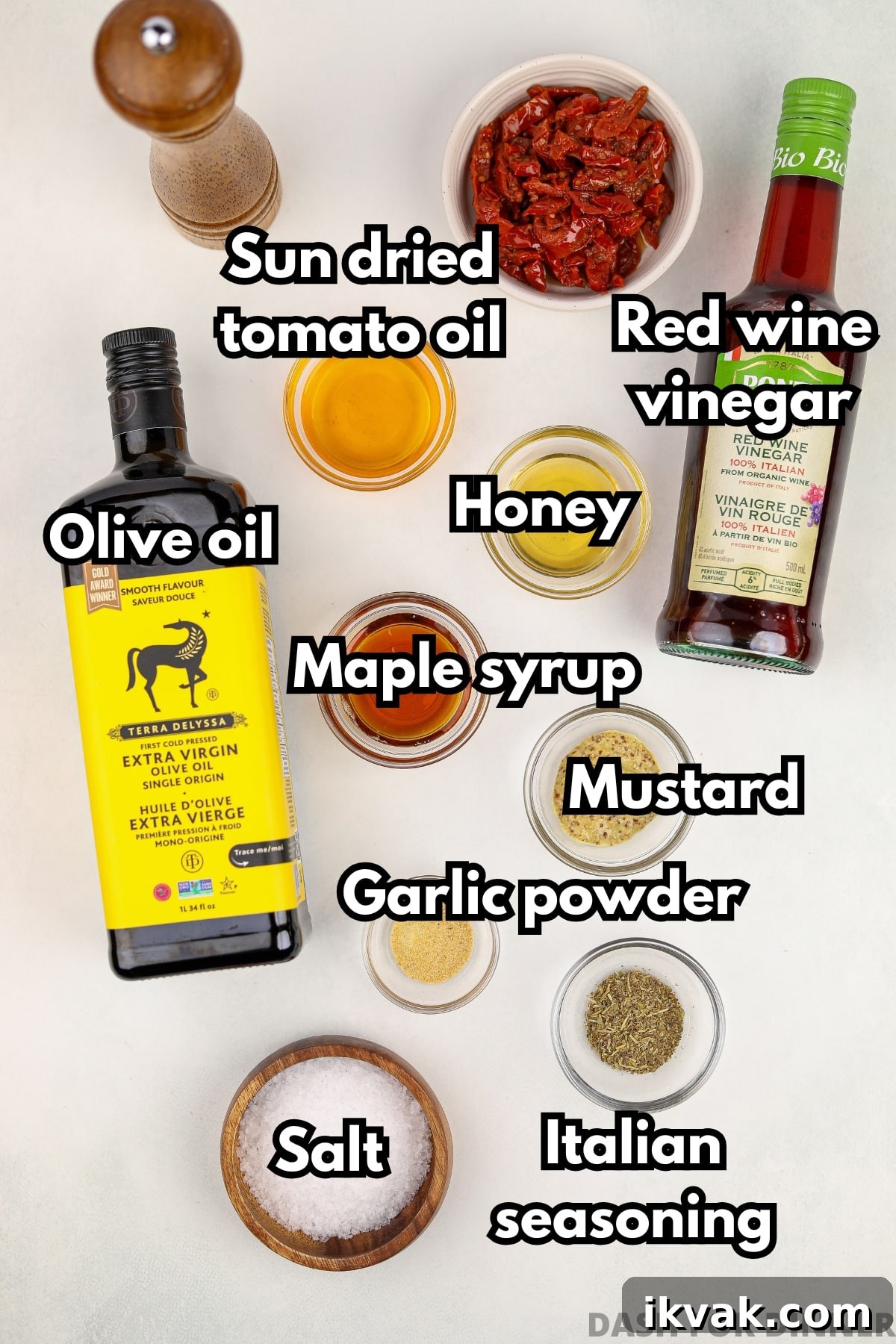 The ingredients needed to make homemade vinaigrette, including honey, vinegar, olive oil, and flavoring ingredients.