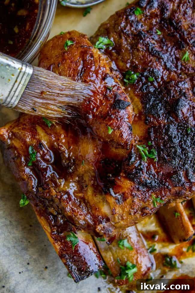 slow cooker ribs being brushed with glaze