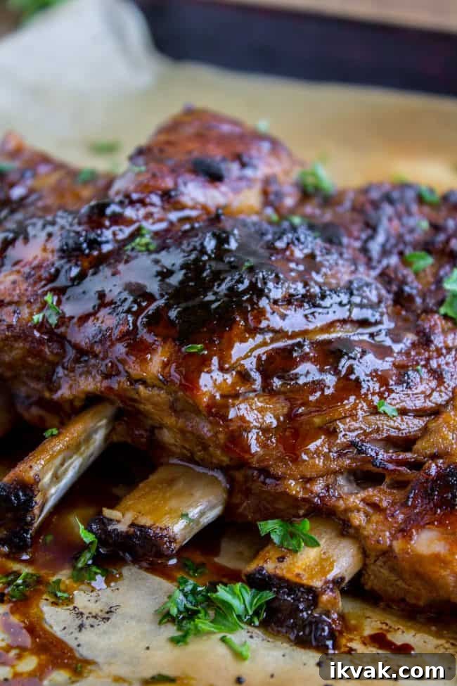 Close-up of glazed, slow cooker ribs garnished with chopped parsley.