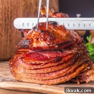 Honey-Baked Ham with Brown Sugar Glaze Recipe 11 Whole honey baked ham on wooden cutting board ready to slice showing caramelized exterior - Hostess At Heart