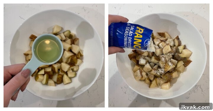 diced potatoes in white bowl while adding oil and ranch seasoning