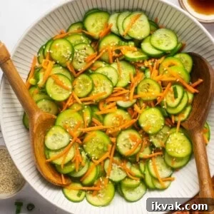 Crisp Cucumber and Carrot Salad with Tangy Dressing 8 cucumber carrot salad with 2 wooden spoons in a white bowl