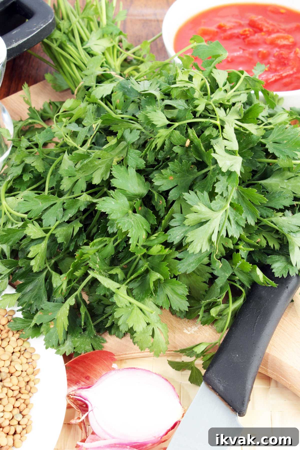 20 Flavorful Dill Substitutes for Cooking and Garnish 7 A bunch of fresh parsley on a chopping board with a knife and other ingredients for a soup.