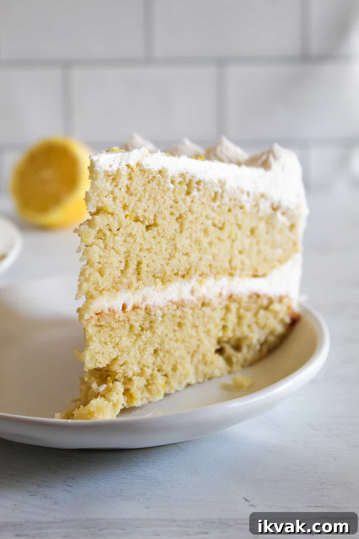 gluten free lemon cake slice on a white plate.