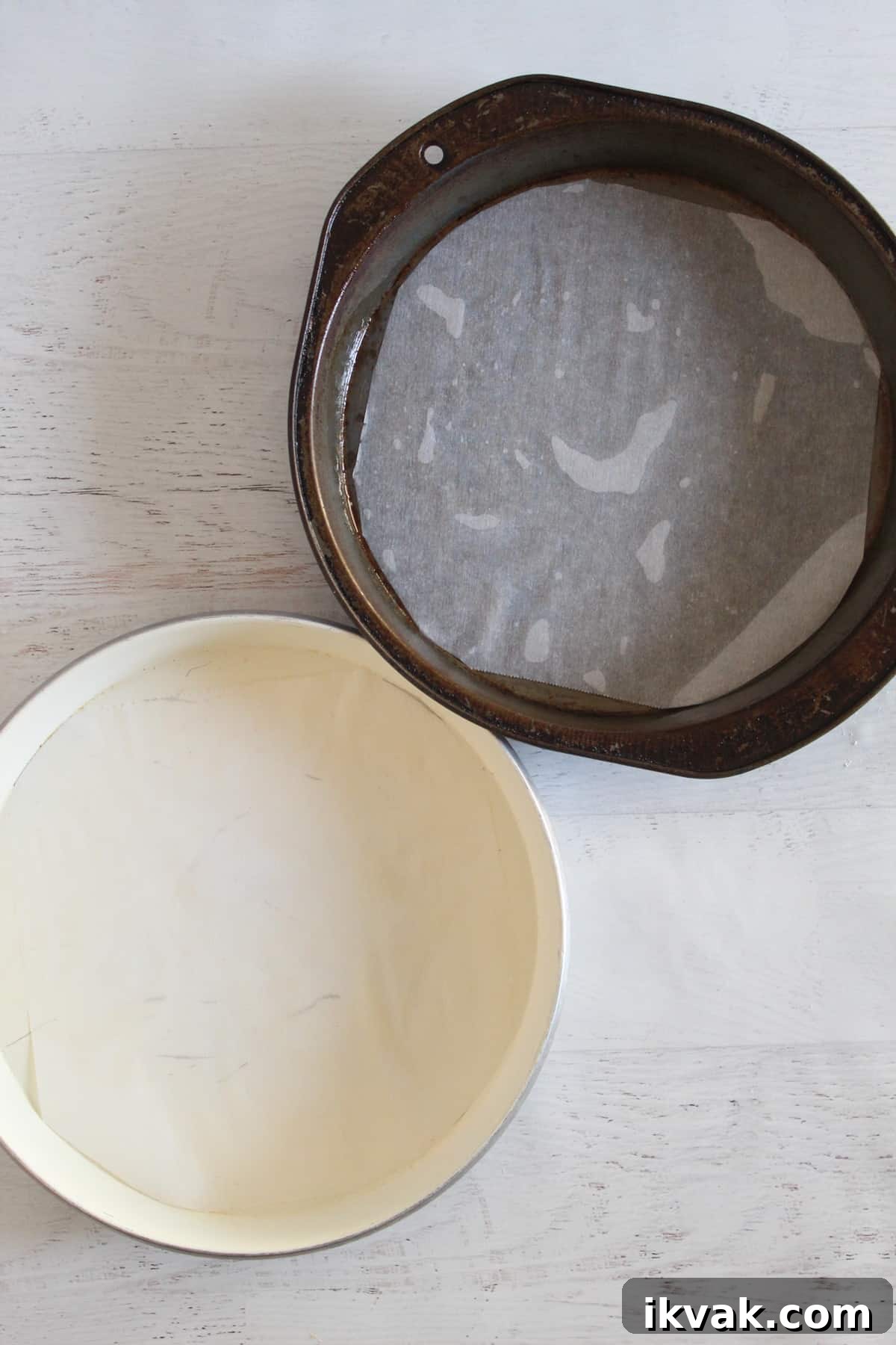 Two Greased cake pans with parchment paper