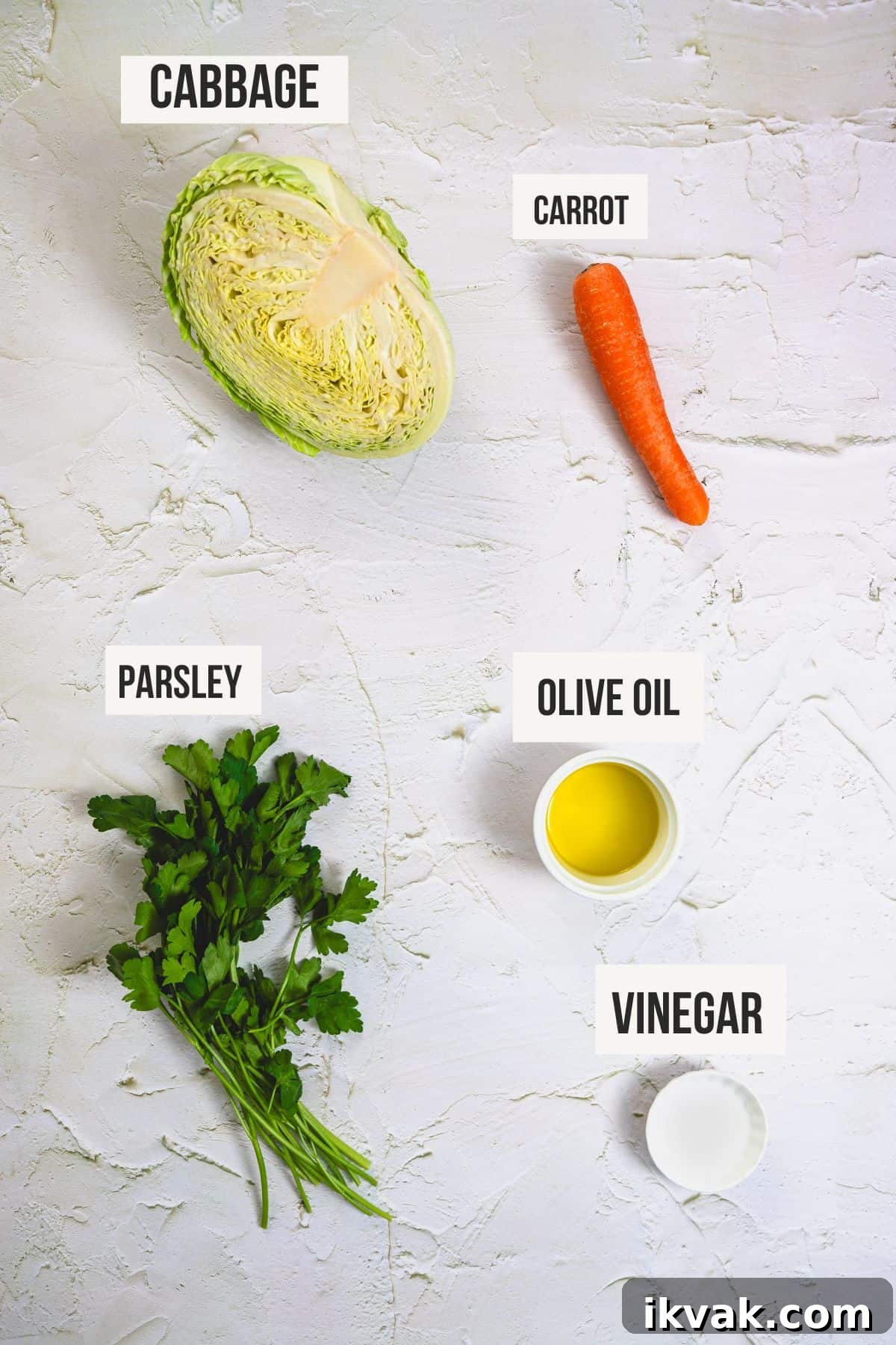 the ingredients to make Greek cabbage salad on a white surface.