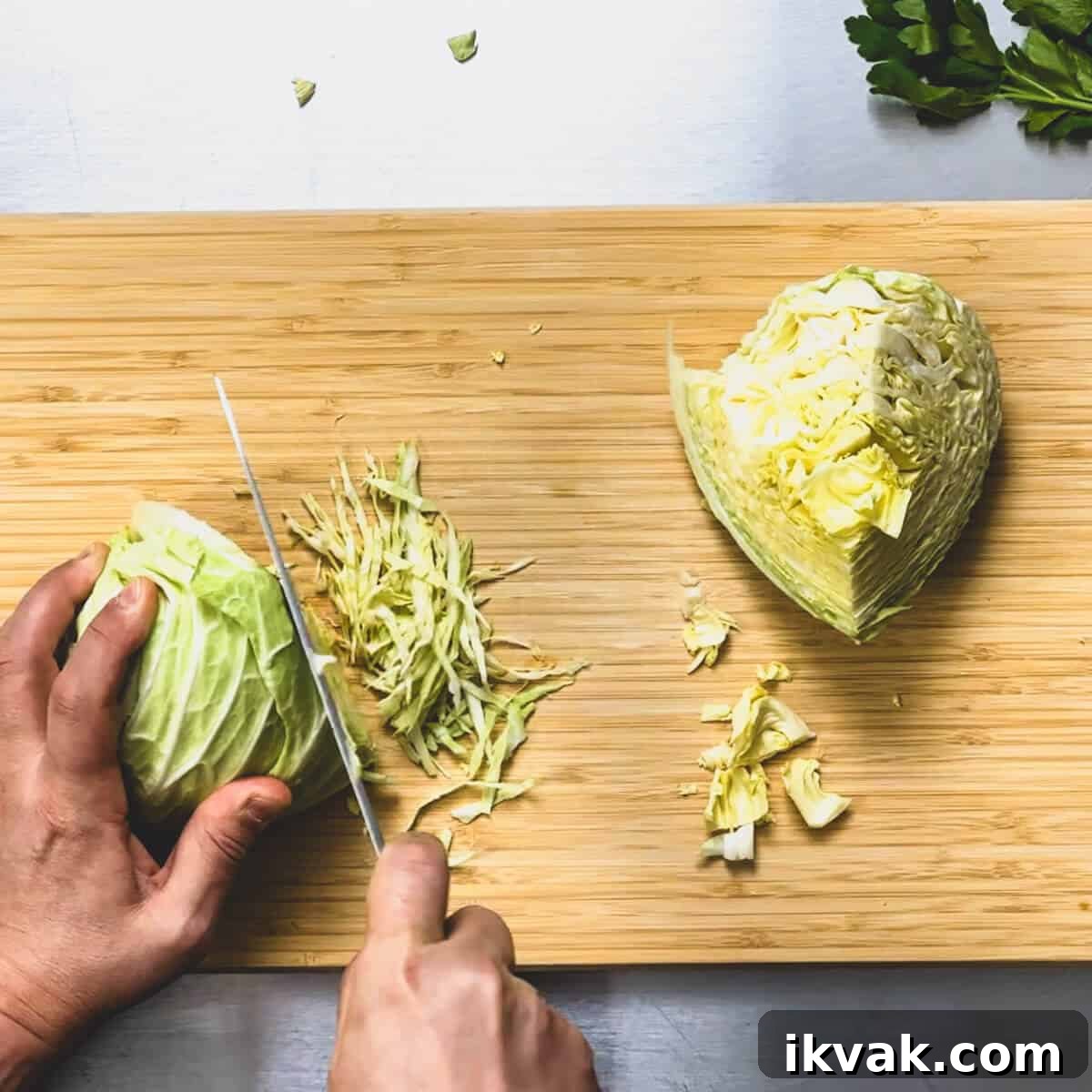 cabbage being shredded finely on a chopping board.
