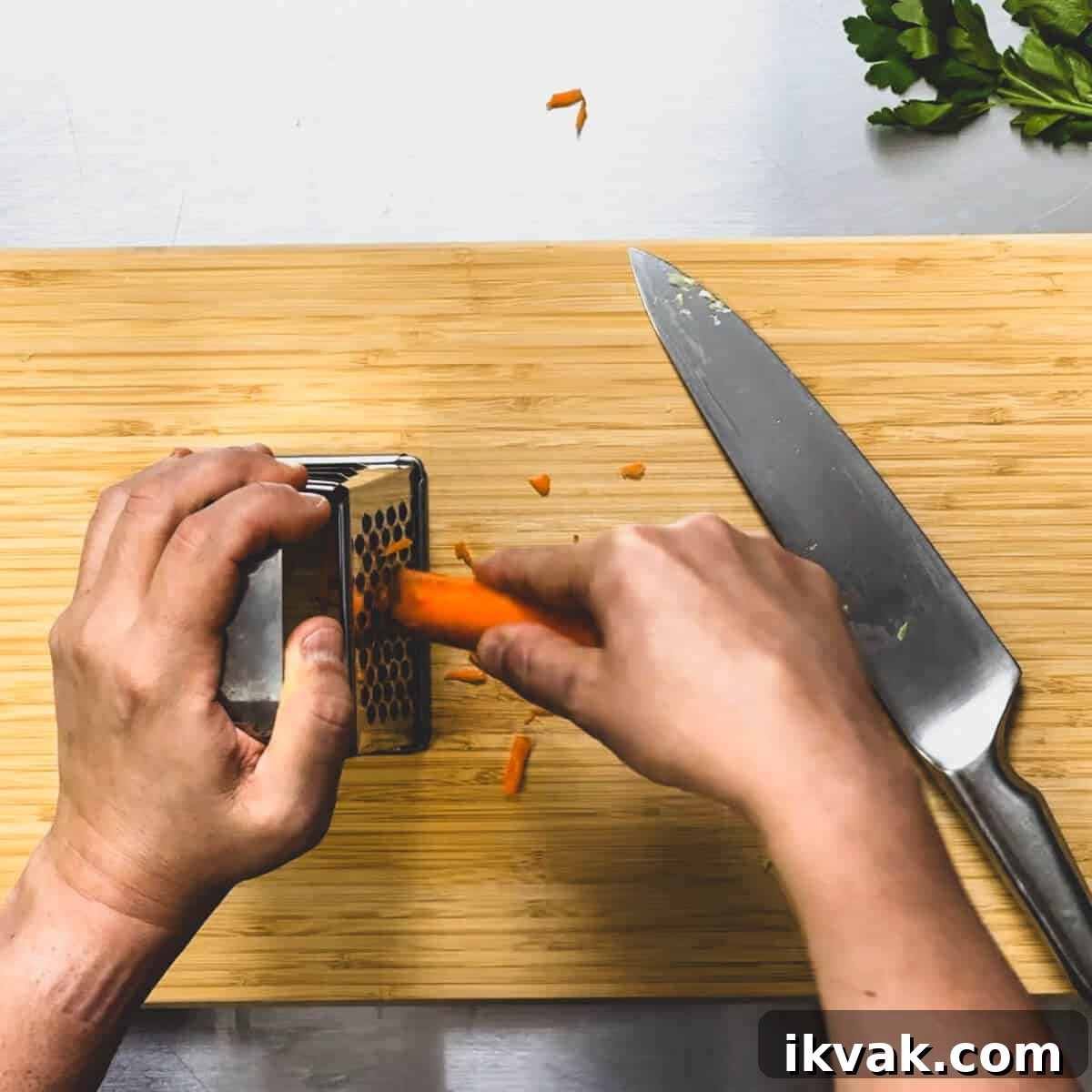 a carrot being grated with a box grater.