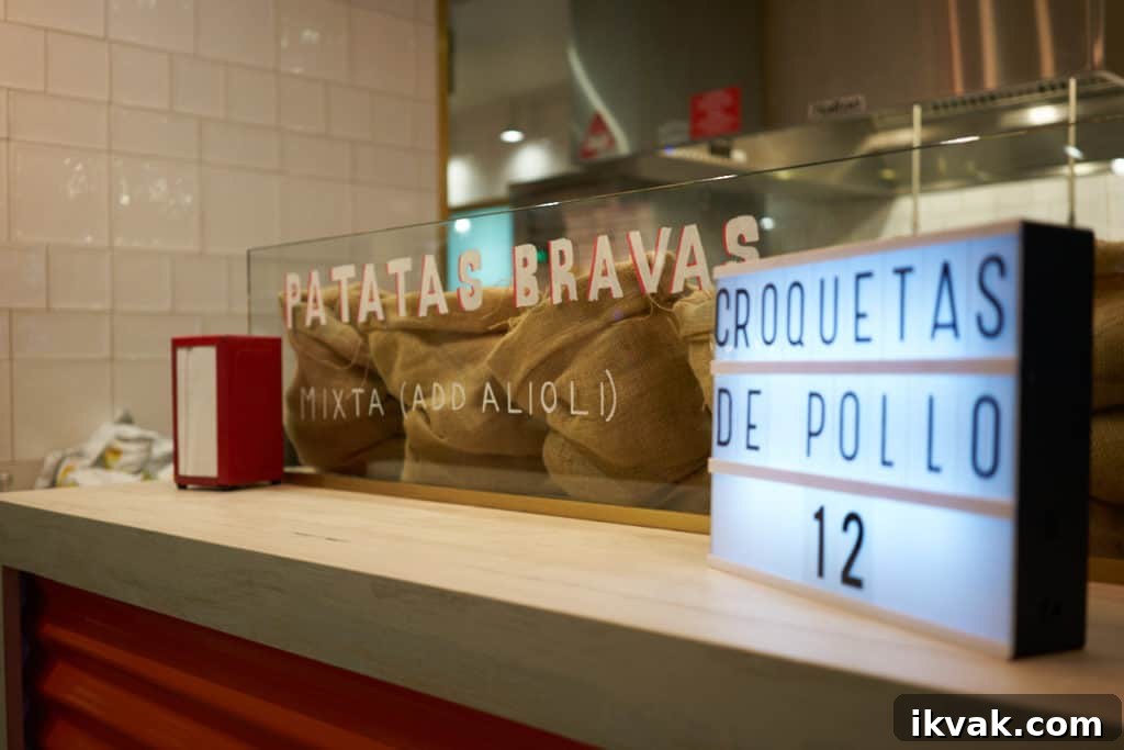 Patatas bravas written on glass at a kiosk.