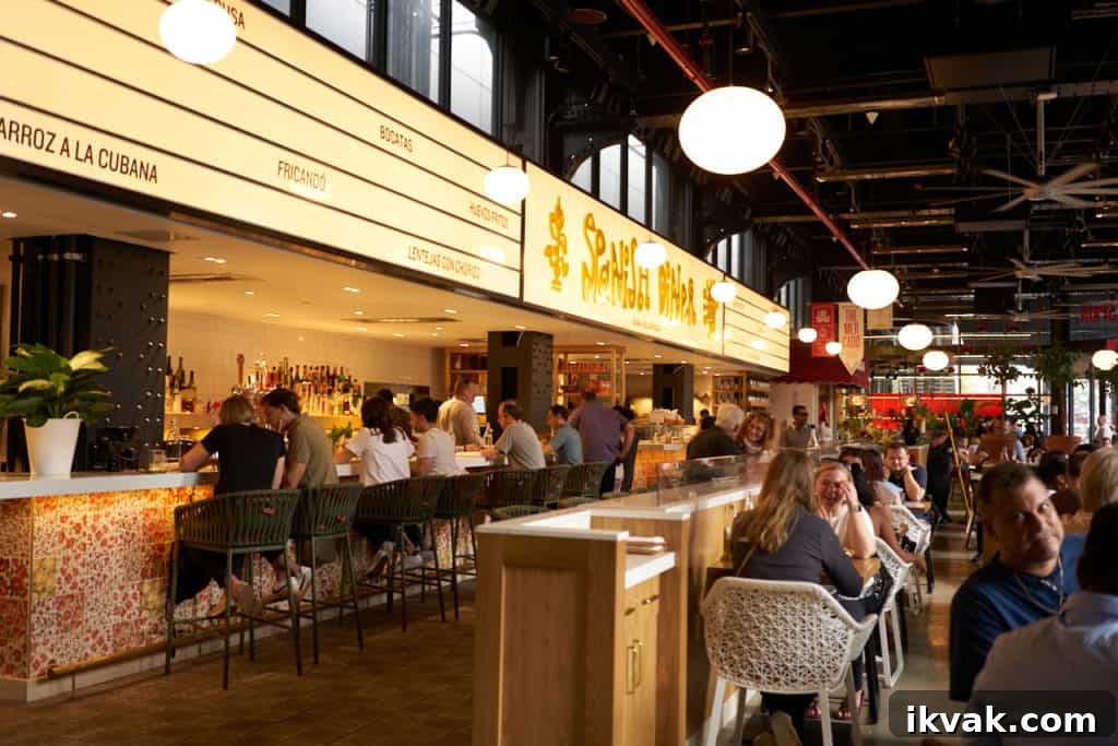 People sitting at tables and at a bar inside Spanish Diner, one of the restaurants at Mercado Little Spain. 