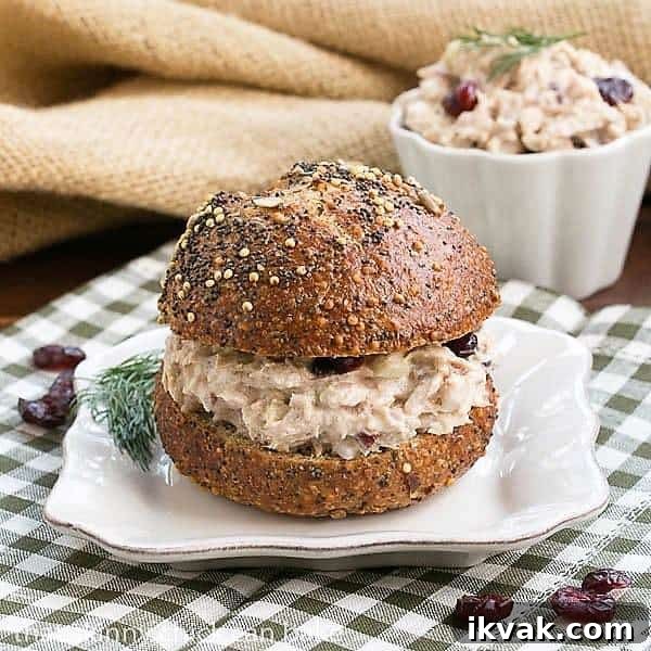 Tuna salad on a bun on a square white plate