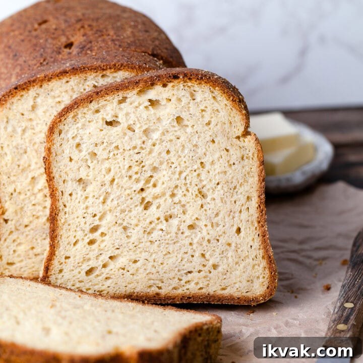 sliced gluten free sandwich bread leaning against each other, a small bowl with butter in the back