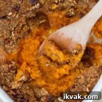 Ultimate Sweet Potato Casserole Recipe with Crispy Topping 2 overhead view of sweet potato casserole with wooden spoon