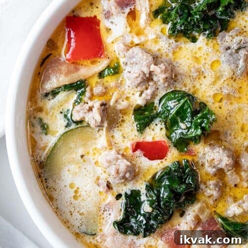 overhead view of zuppa toscana soup in a large ceramic pot with a soup ladel