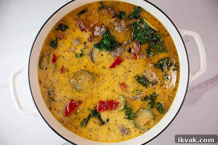 overhead view of low carb zuppa toscana soup in a white ceramic pot done simmering and ready to serve