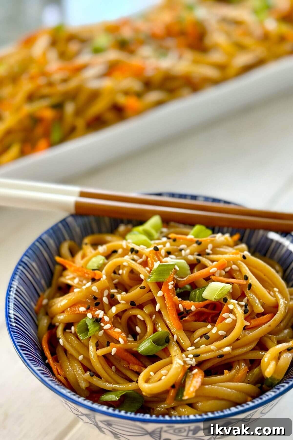 serving dish and single bowl of garlic sesame noodles.