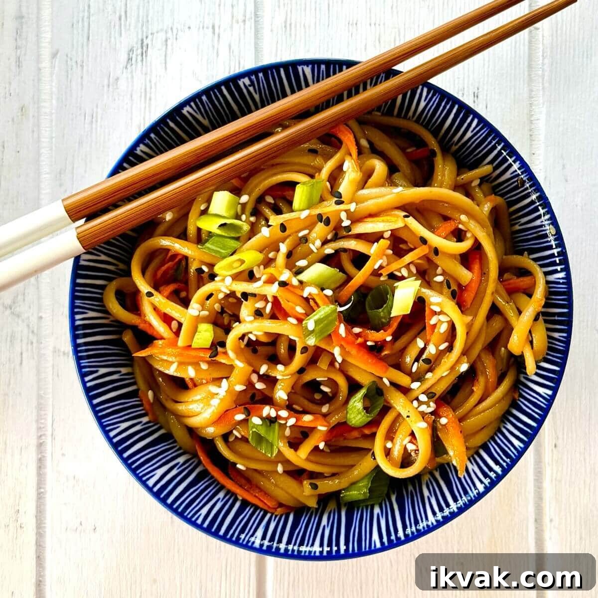 serving of sesame noodles with chopsticks.