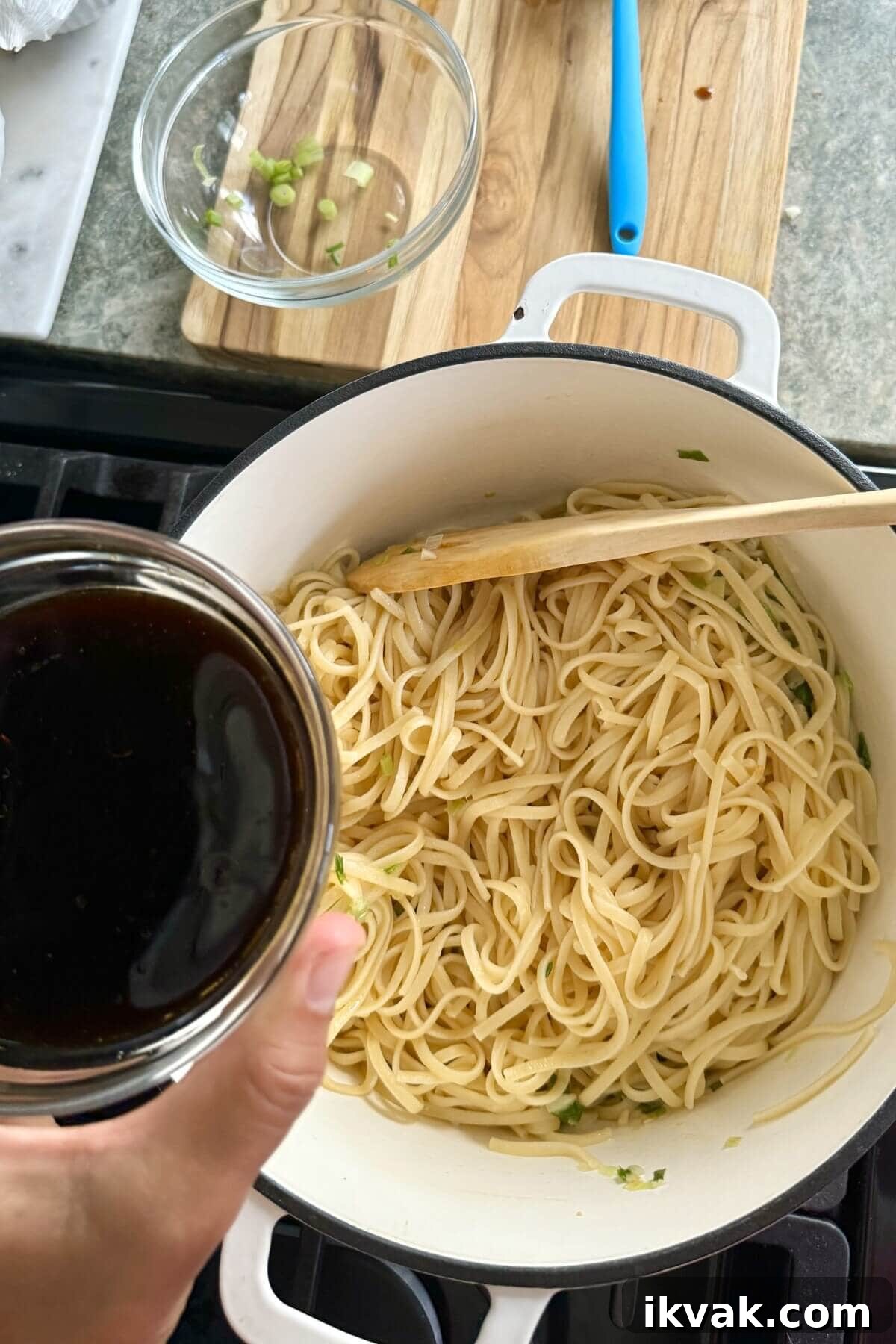 adding sauce to sesame noodles.