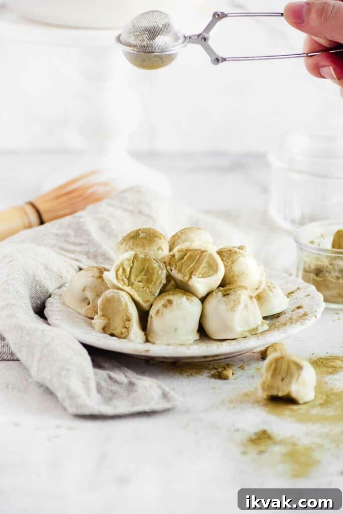 sprinkling matcha powder on prepared matcha truffles