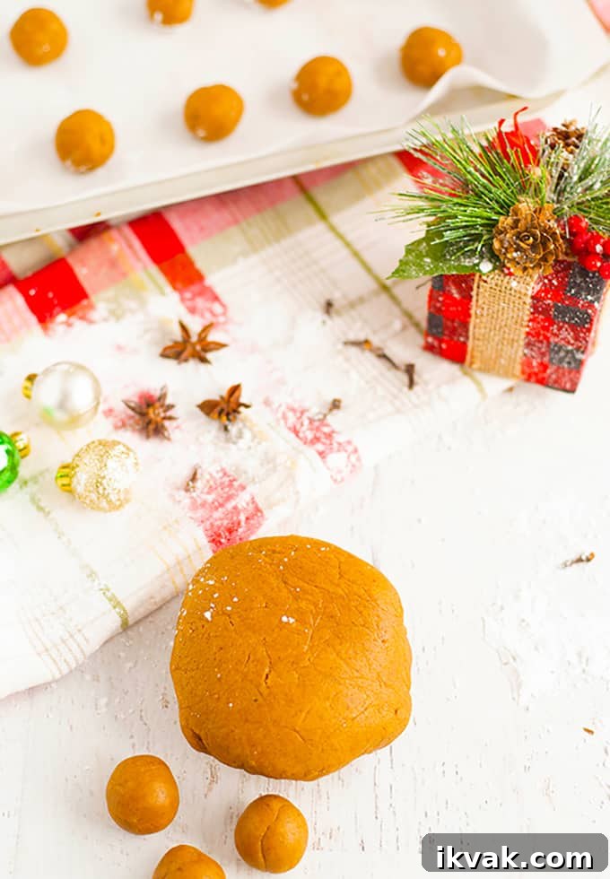 Pfeffernüsse: Traditional German Christmas Spice Cookies 8 cookies on a baking sheet next to a Christmas gift