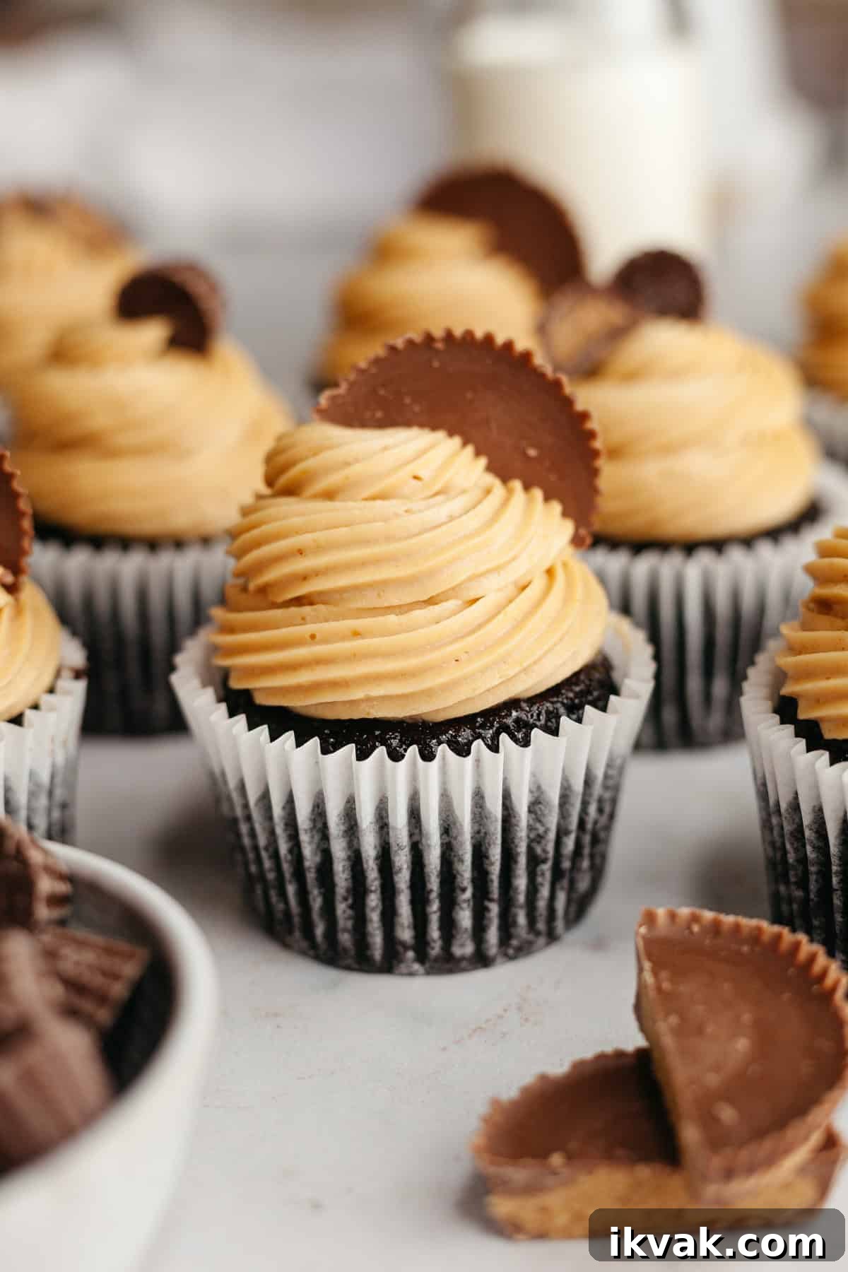 Chocolate cupcakes frosted with peanut butter frosting and topped with Reese's peanut butter cups.
